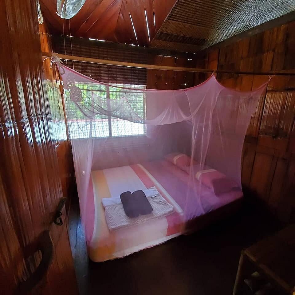 Letto in stile pangah con zanzariera in una camera del Saloma Villagestay
