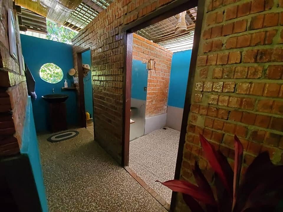 Bagno all'aperto in mattoni del Saloma Villagestay, con lavandino e doccia immersi nel verde